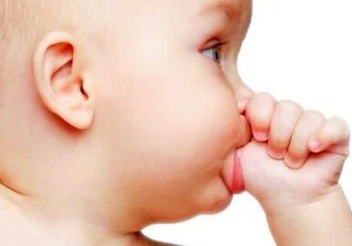 Baby sucking thumb, close-up side profile.