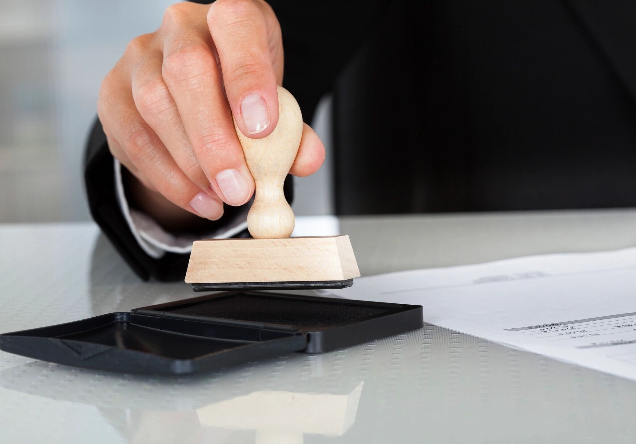 Hand stamping document on a desk.