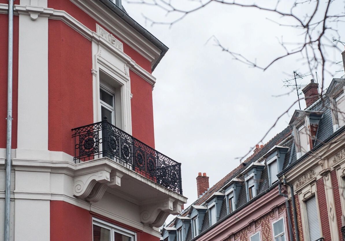 Red building with ornate balcony and windows.