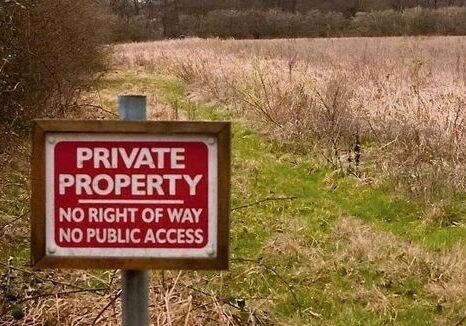 Private property sign on grassy field.