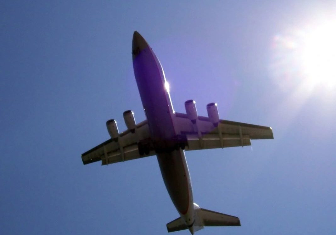 Airplane flying high in clear sky.