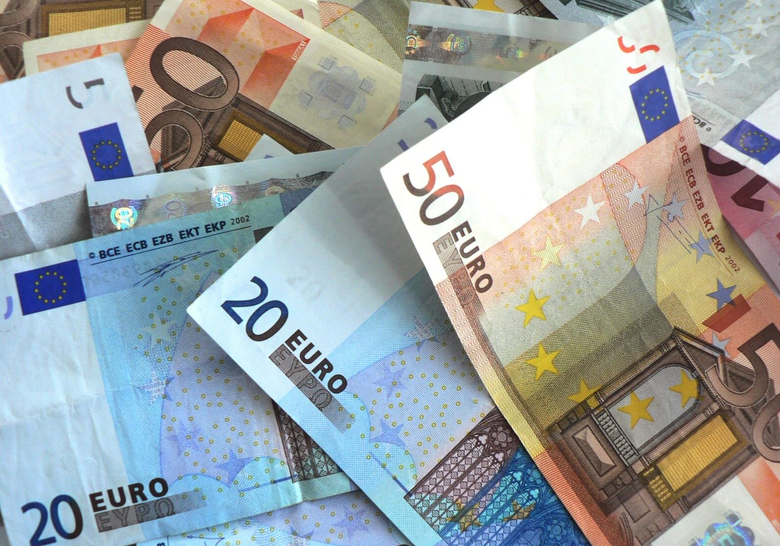 Euro banknotes in various denominations scattered.
