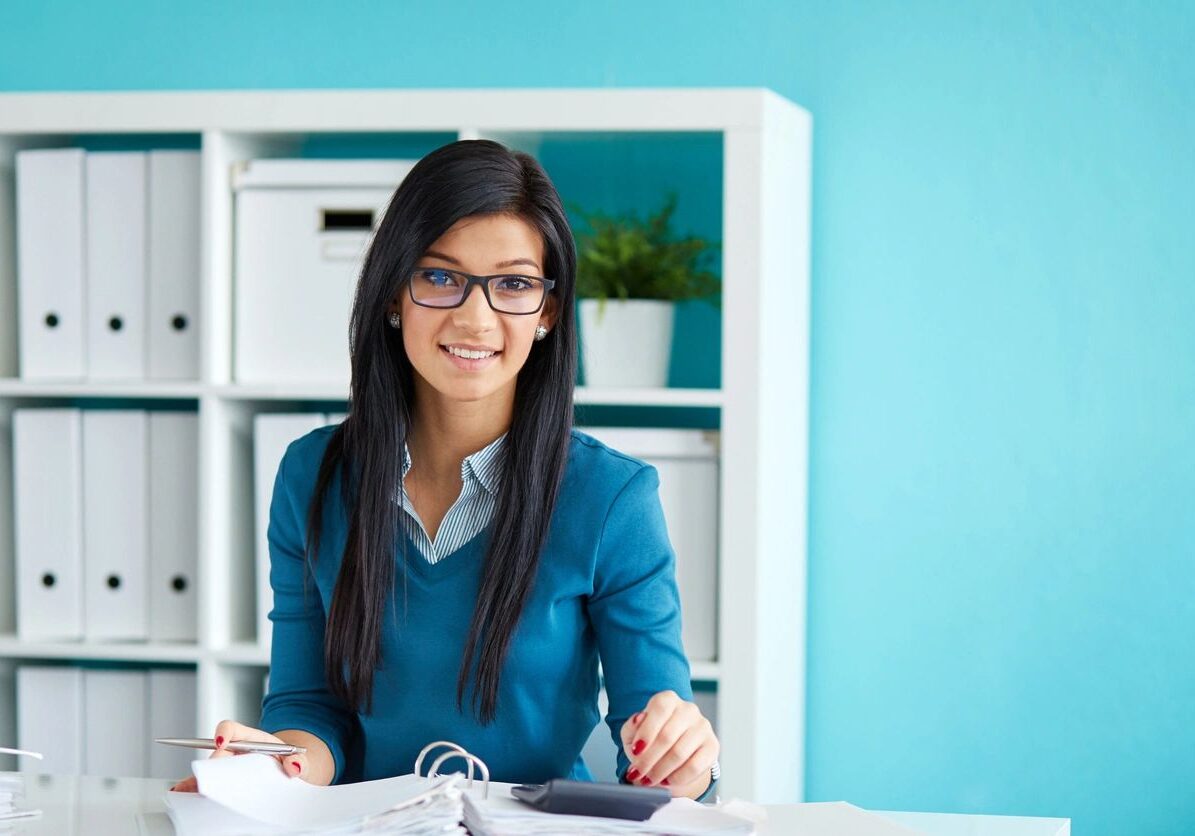 Woman working at desk in office setting.