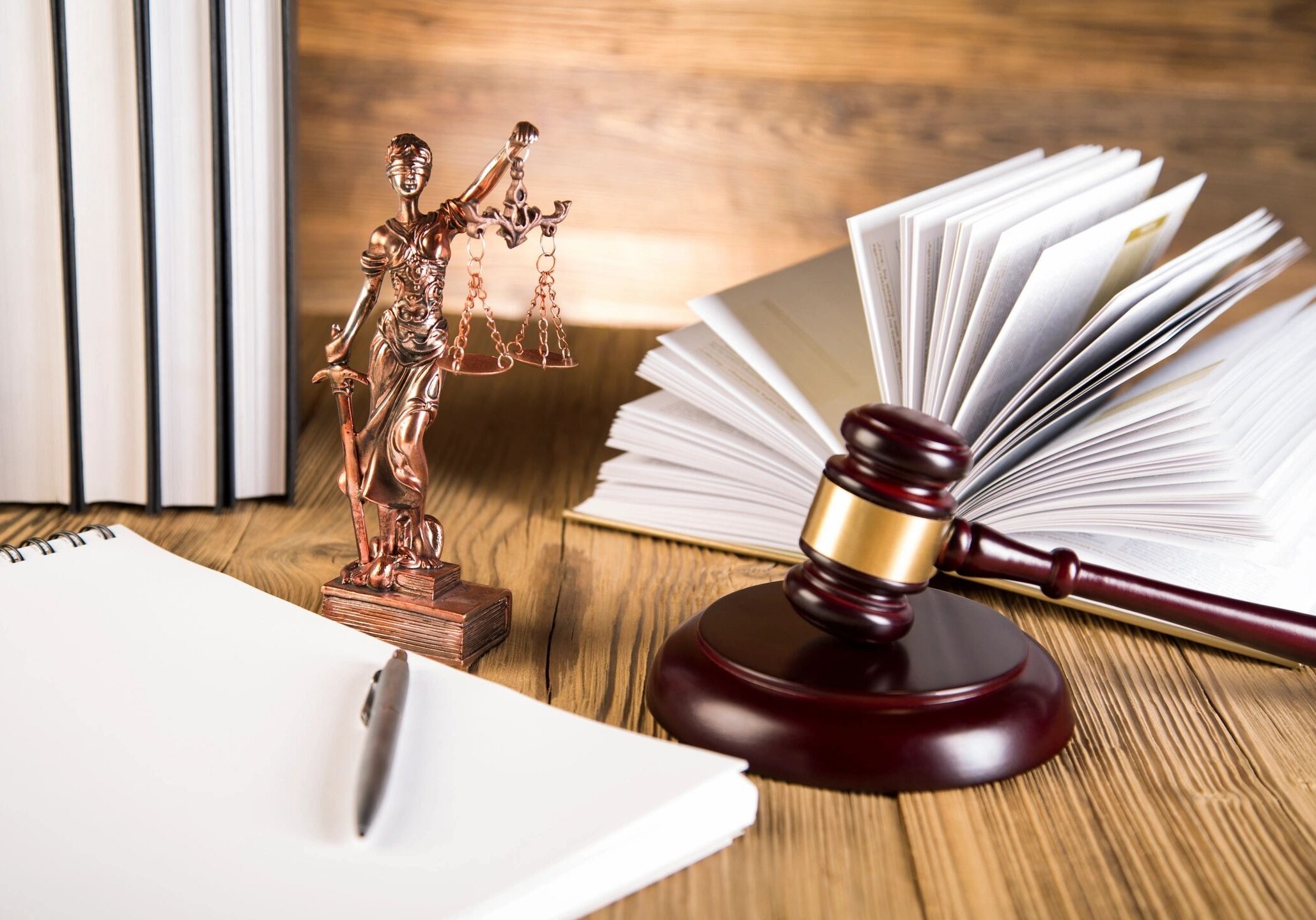 Gavel, Lady Justice, open book, and notepad.