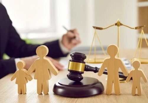 Wooden family figures with gavel and scales.