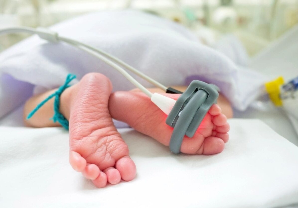 Newborn baby feet with medical sensor.