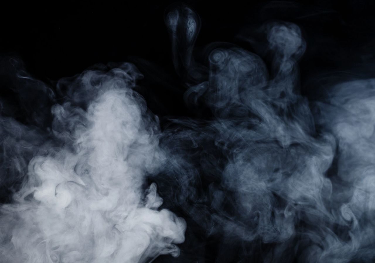 White smoke swirling on black background.