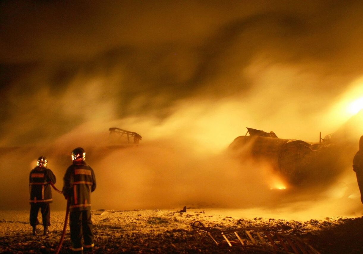 Firefighters battling large blaze at night.