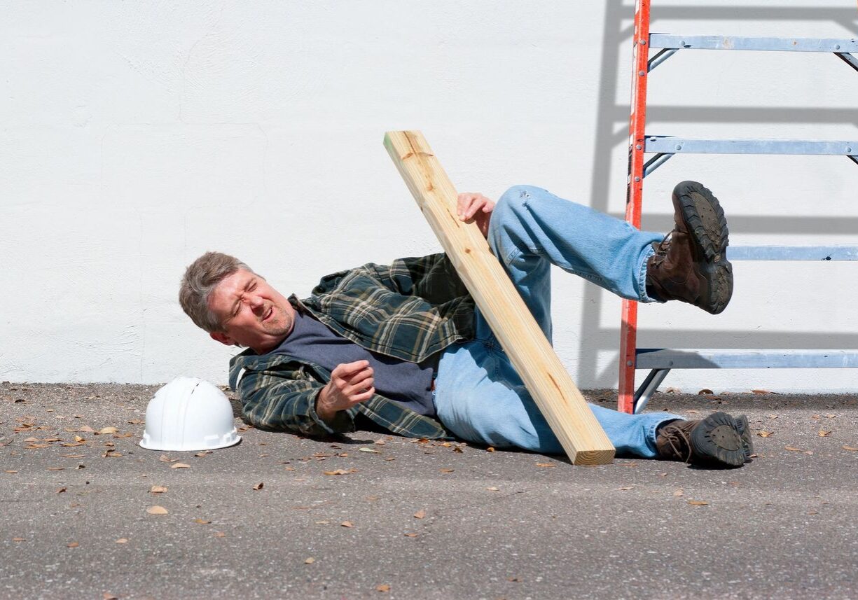 Man falling with ladder and wooden plank.