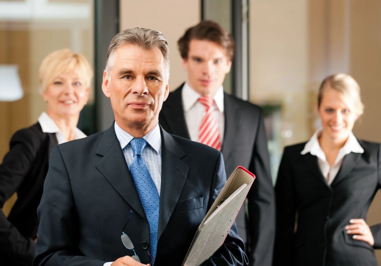Business team in formal attire, posing confidently.